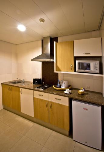 a kitchen with a sink and a microwave at Vip Executive Suites Maputo in Maputo