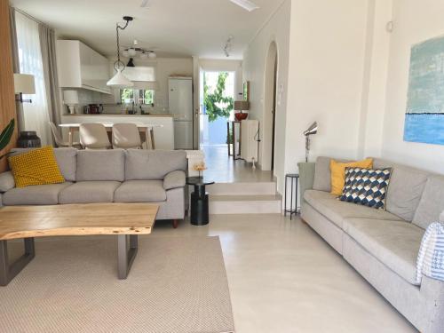 a living room with a couch and a table at Maia beach house in Rafina