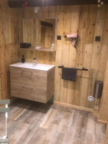 La salle de bains est pourvue d'un lavabo et d'un mur en bois. dans l'établissement ARTIN, à Marseille