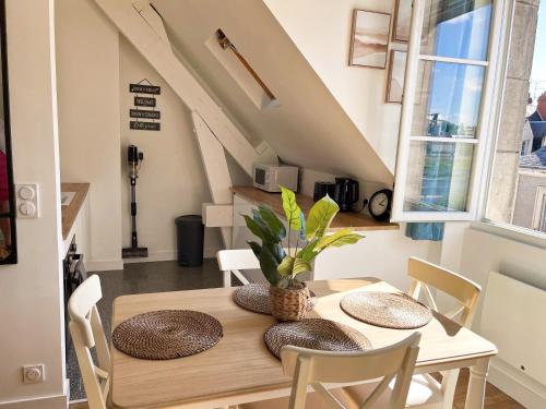 een eetkamer met een houten tafel en stoelen bij Appartement duplex rénové vue sur la Loire in Blois