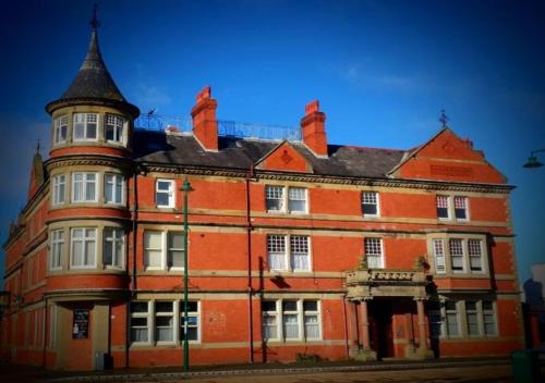 a large red brick building with a tower at VALE VIEW APARTMENT, Prestatyn, North Wales - a stylish, dog-friendly holiday let just a 5 min walk to beach & town! in Prestatyn