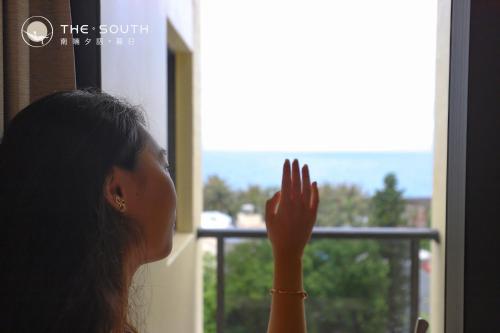 a woman looking out a window at a view at The South-Sunset in Hengchun