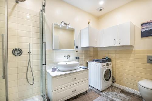 a bathroom with a sink and a washing machine at Vilnius city best view apartments in Vilnius