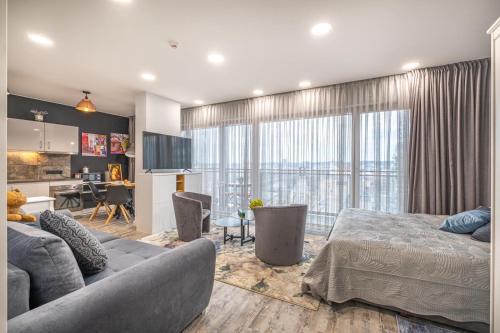 una camera con letto e un soggiorno con cucina di Vilnius city best view apartments a Vilnius
