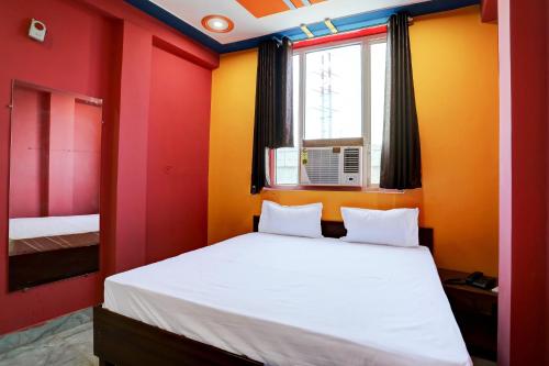 a bedroom with a bed with red and yellow walls at OYO Hotel Sk Inn in Ghaziabad