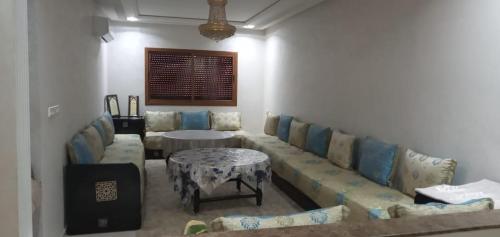 a living room with a couch and a table at Dar fatima in Temara