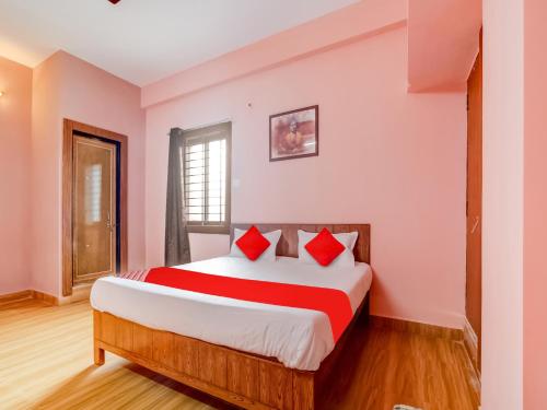 - une chambre avec un grand lit et des oreillers rouges dans l'établissement Hotel Crown Square, à Bhopal