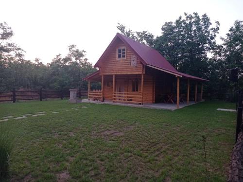 a log cabin in a field with a yard at Vinci brvnara Omladinac in Vinci