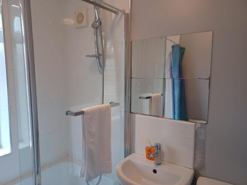 a white bathroom with a shower and a sink at Ferndale Place - Huku Kwetu Luton- Spacious 4 Bedroom Suitable & Affordable Group Accommodation - Business Travellers in Luton