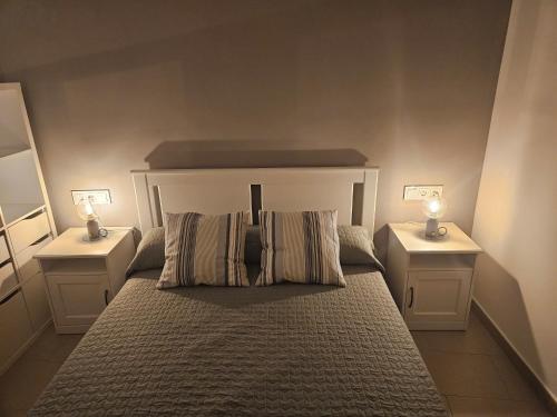 - une chambre avec un grand lit et 2 tables de chevet dans l'établissement Apartments Zarate, à Grenade