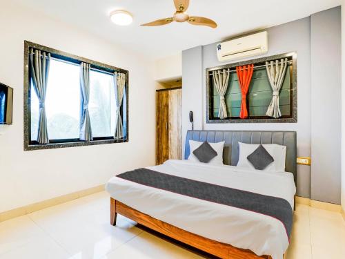 a bedroom with a bed and two windows at Sairup Stays in Navi Mumbai