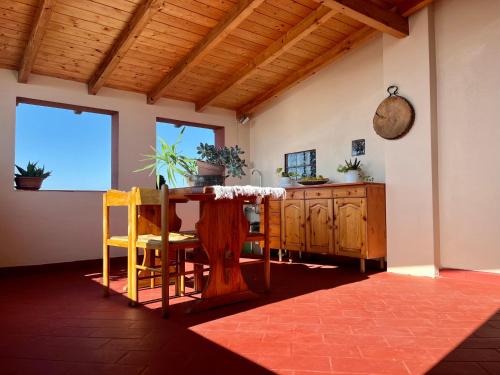 Casa di Rosy في San Sperate: غرفة طعام مع طاولة وكراسي خشبية
