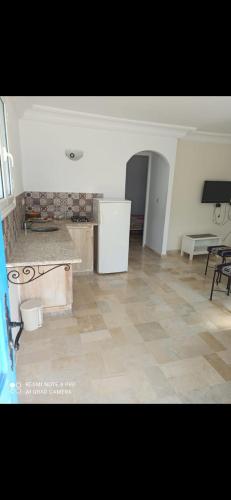 Habitación con cocina con mesa y nevera. en good vacation en Houmt El Souk