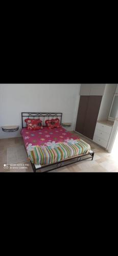 1 cama con edredón rojo en un dormitorio en good vacation en Houmt El Souk