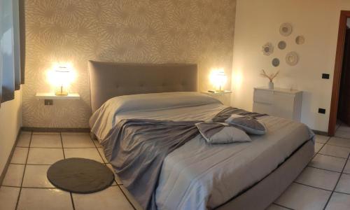 een slaapkamer met een groot bed met 2 lampen bij Donna Rosa in Pagani