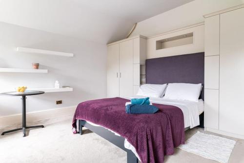 ein Schlafzimmer mit einem Bett mit einer lila Decke in der Unterkunft Yeovil in Rathgar