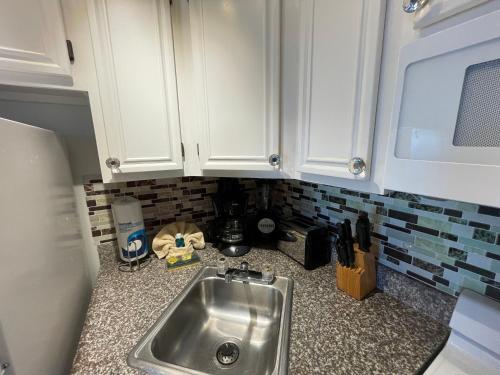 a kitchen counter with a sink and a microwave at Casa Del Mar Sun Diamond One Bedroom Retreat - Galveston in Galveston