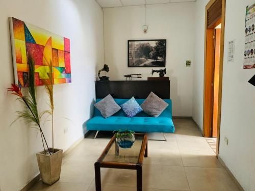 sala de estar con sofá azul y mesa en Hostal Zaguán Caldense, en Manizales