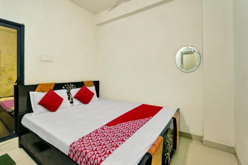 um quarto com uma cama com almofadas vermelhas em OYO Flagship Residence Inn Guest House em Patna