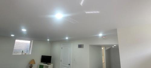 a white room with a light on the ceiling at Comfy basement near KW airport in Kitchener