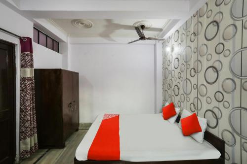 a bedroom with a white bed with red pillows at OYO Flagship Corporate House in Gurgaon