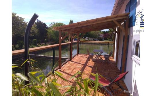 une terrasse avec des chaises, une table et une clôture dans l'établissement Ma cabane au bord de l'eau, à La Tremblade