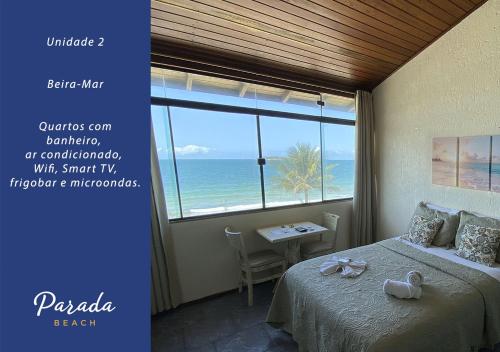 a bedroom with a bed and a view of the ocean at Parada Beach Beira-Mar e Aptos 70m do Mar in Florianópolis