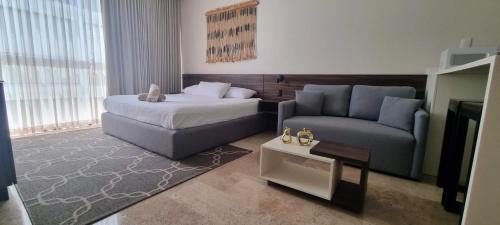 un soggiorno con un letto e un divano di Cozy Studio Aldea Zama Tulum WIFI Alberca a Tulum