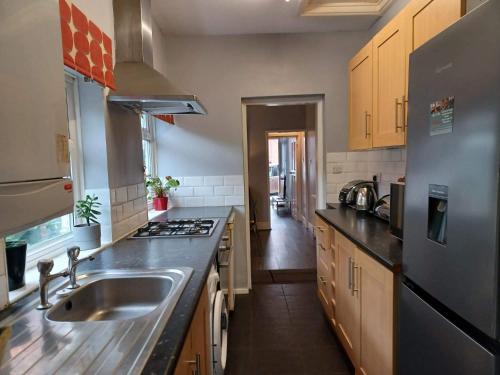 uma cozinha com um lavatório e um fogão forno superior em Ferndale House-Huku Kwetu Luton -Spacious 4 Bedroom House - Suitable & Affordable Group Accommodation - Business Travellers em Luton