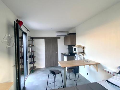 Studio atypique Le Mans في لو مان: مطبخ صغير مع طاولة وكراسي في الغرفة