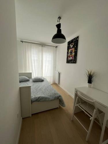 une chambre avec un lit et une table dedans dans l'établissement Magnifique appartement sur la seine, à Alfortville