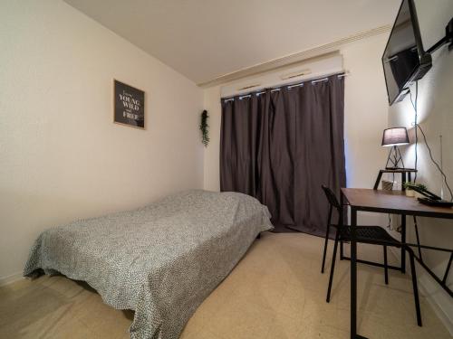um quarto com uma cama, uma mesa e uma secretária em Appartement tout équipe wifi à 6 min St Charles em Marselha