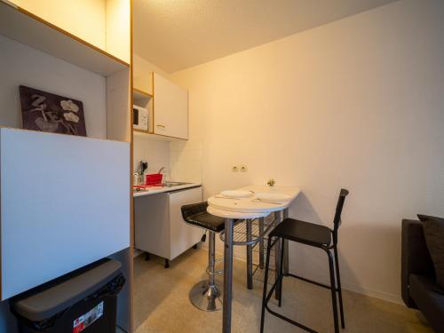 - une petite cuisine avec une petite table et des chaises dans l'établissement Appartement tout équipe wifi à 6 min St Charles, à Marseille