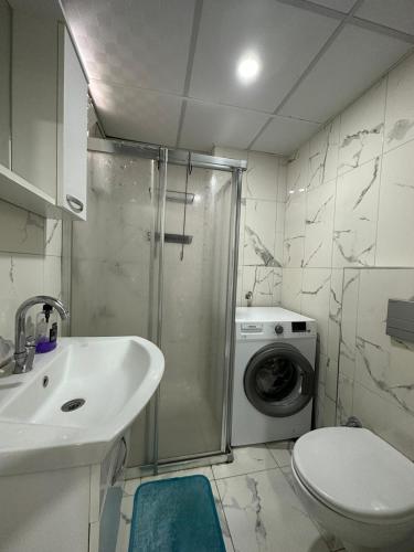 a bathroom with a shower sink and a washing machine at Tatil için ev in Antalya