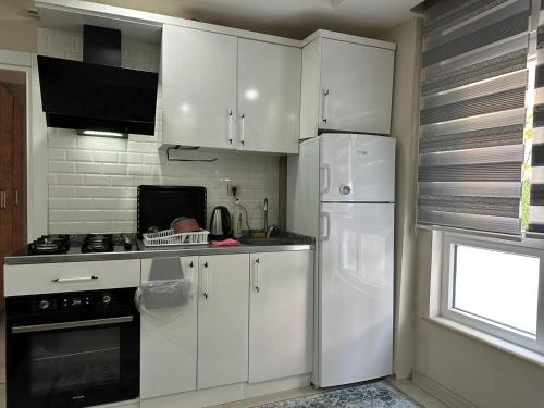 a kitchen with white cabinets and a white refrigerator at Tatil için ev in Antalya