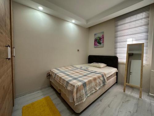 1 dormitorio con 1 cama con manta a cuadros en Tatil için ev, en Antalya