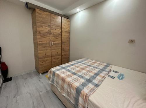 1 dormitorio con 1 cama y armario de madera en Tatil için ev, en Antalya