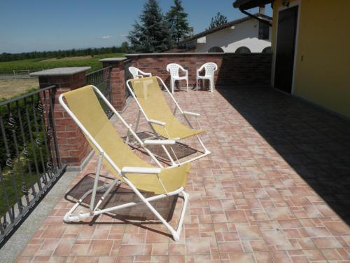 a group of chairs sitting on a brick patio at B&B Da Levi Piana Del Sole in Rivalta Bormida