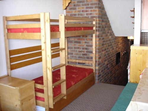 a bedroom with two bunk beds in a brick wall at Appartement duplex aux Ménuires 4 personnes in Les Menuires