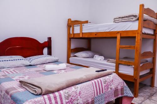 a bedroom with two bunk beds and a ladder at Pousada Bela Vista in Inconfidentes