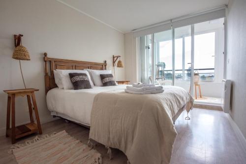 una camera da letto con un grande letto con una grande finestra di Depto con exquisita Vista al Lago y Tinaja a Puerto Varas