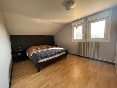 une chambre avec un lit et deux fenêtres dans l'établissement Chalet Marie-Louise - Gérardmer, à Gérardmer