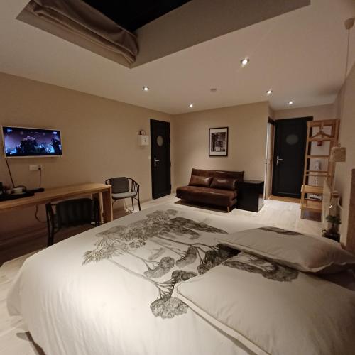 une chambre avec un grand lit blanc et un canapé dans l'établissement Serenity Indepedent Suite near to Disneyland & Paris, à Bussy-Saint-Georges