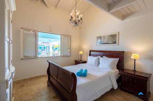 a bedroom with a bed with two blue shoes on it at Marina view apartments in Kralendijk