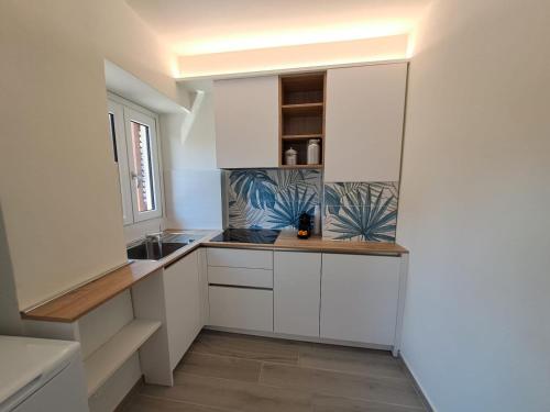 a kitchen with white cabinets and a sink at Stone House in San Maurizio dʼOpaglio