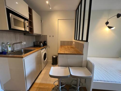 cocina pequeña con fregadero y cama en Dream Dwell Paris -Studio with Balcony 800m to Trocadéro and Tour Eiffel, en París