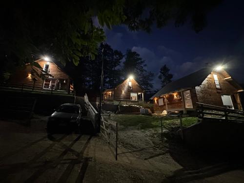 a couple of buildings at night with lights on at Villa Pax in Peje