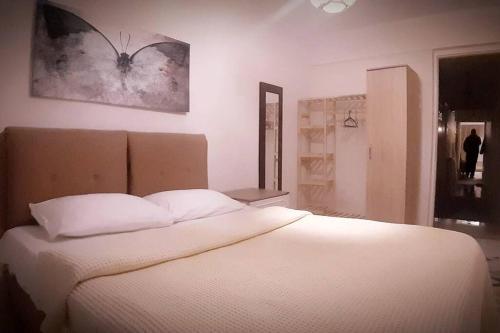 um quarto com uma cama branca e um quadro na parede em 3+1 , historical elevator, warm house next to sea em Konak