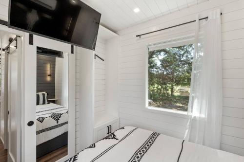 um quarto branco com uma cama e uma janela em The Lonely Bull Luxury Container Home on 5 Acres em Weatherford