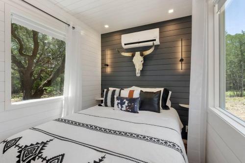 a bedroom with a bed with black and white pillows at The Lonely Bull Luxury Container Home on 5 Acres in Weatherford
